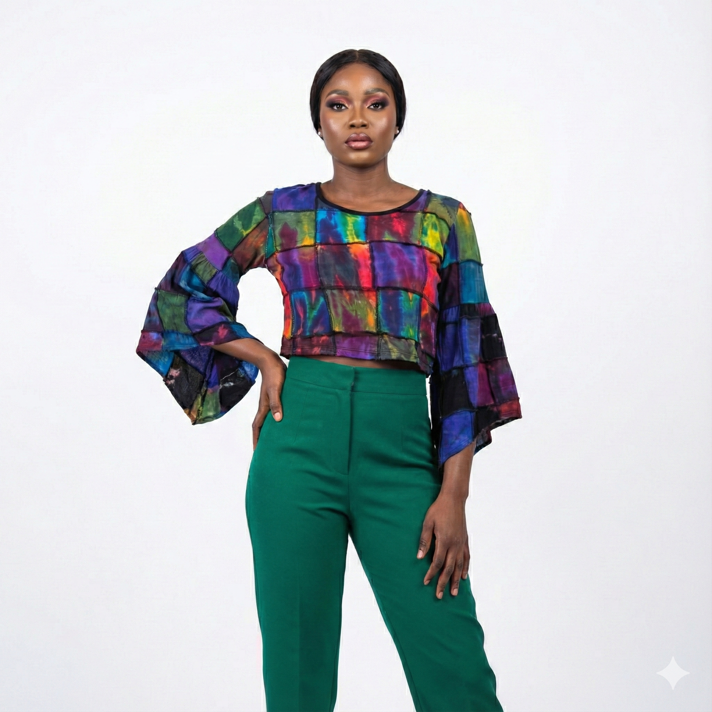 Woman wearing a tie top and green pants on a white background