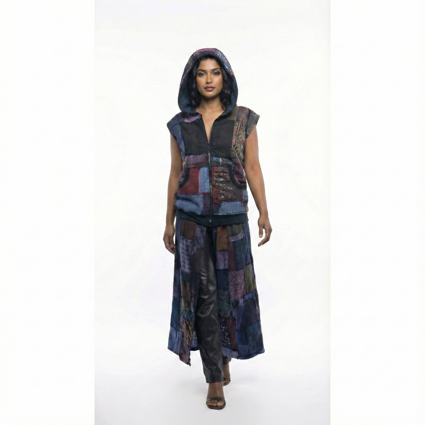 Person wearing a patchwork vest with a hood on a white background