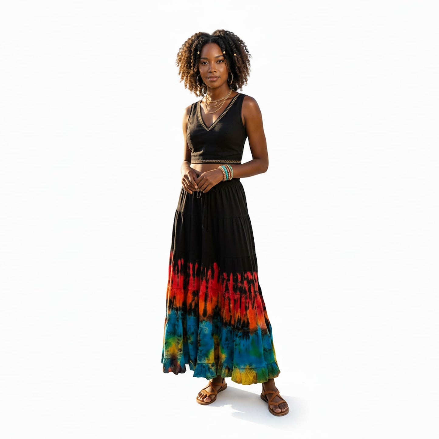 Woman weablack black sleeveless top and black and colorful tie-dye skirt on a white background