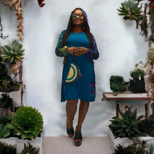 Woman in a blue dress standing among plants with a white background-Sanjules
