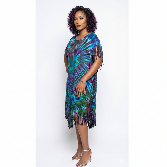 Woman wearing a colorful tie-dye dress with fringe on a white background
