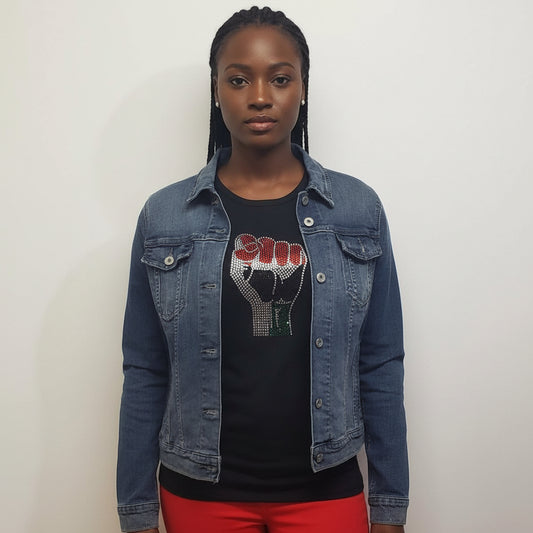 Woman wearing a black unisex Black Power Fist rhinestone t-shirt under a denim jacket.