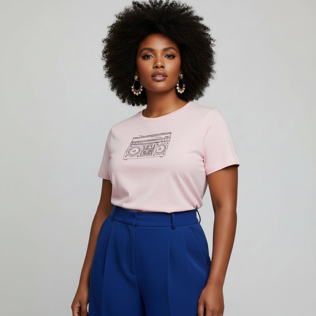 Pink women's t-shirt with a rhinestone retro boom box graphic, worn by a model with natural hair.
