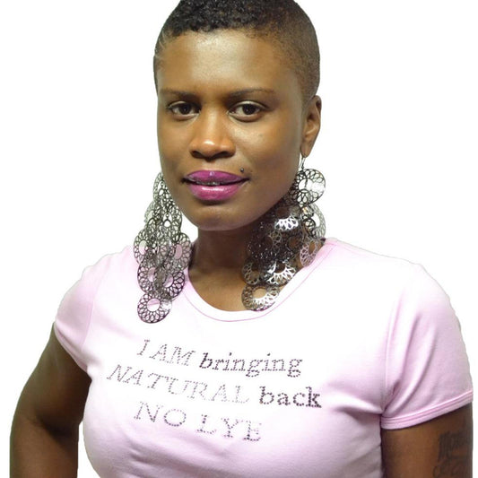 Woman in a pink "I Am Bringing Natural Back No Lye" rhinestone t-shirt with large silver earrings.