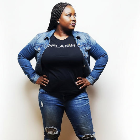 Woman in a black "MELANIN" t-shirt and denim jacket, celebrating Black pride.