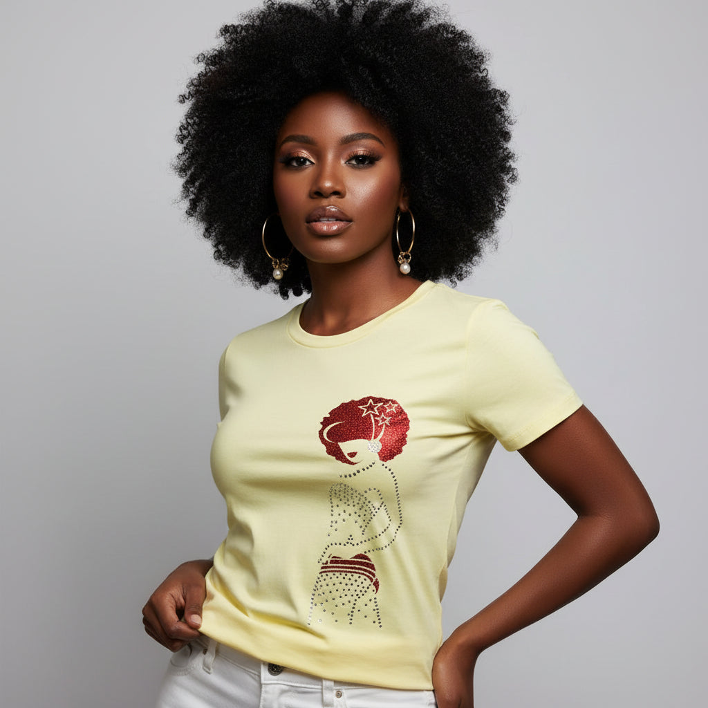 Woman in a light yellow t-shirt with a red rhinestone afro design, white pants, and hoop earrings.