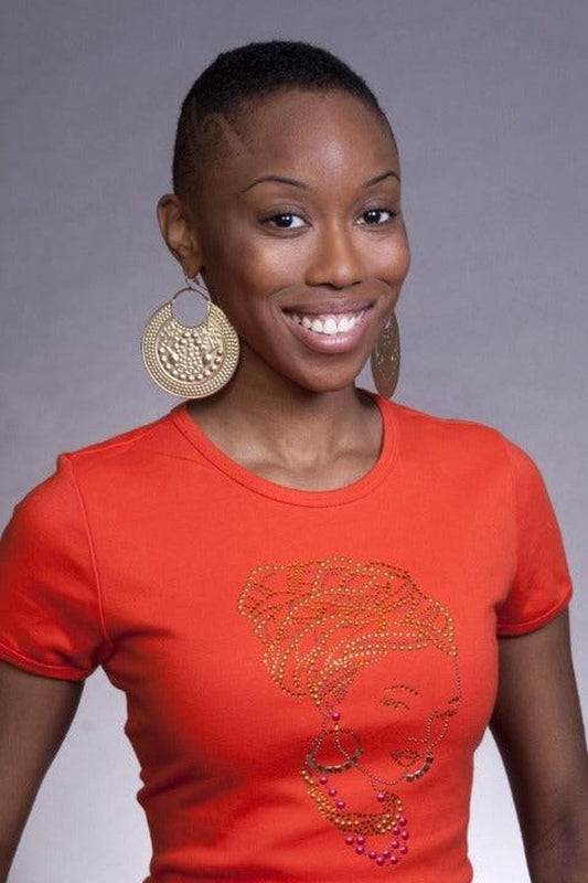 Woman smiling in an orange SanJules t-shirt with a gold rhinestone head wrap crown design.