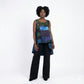 Woman wearing a colorful sleeveless top and black pants on a white background