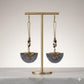 Brass drop earrings with black and white beads, and gray half-moon pendants with gold spirals.