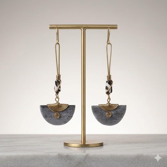 Brass drop earrings with black and white beads, and gray half-moon pendants with gold spirals.