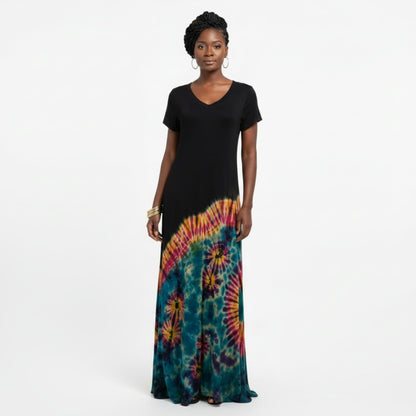 A woman in a short-sleeve maxi dress with a solid black upper section and a colorful tie-dye lower