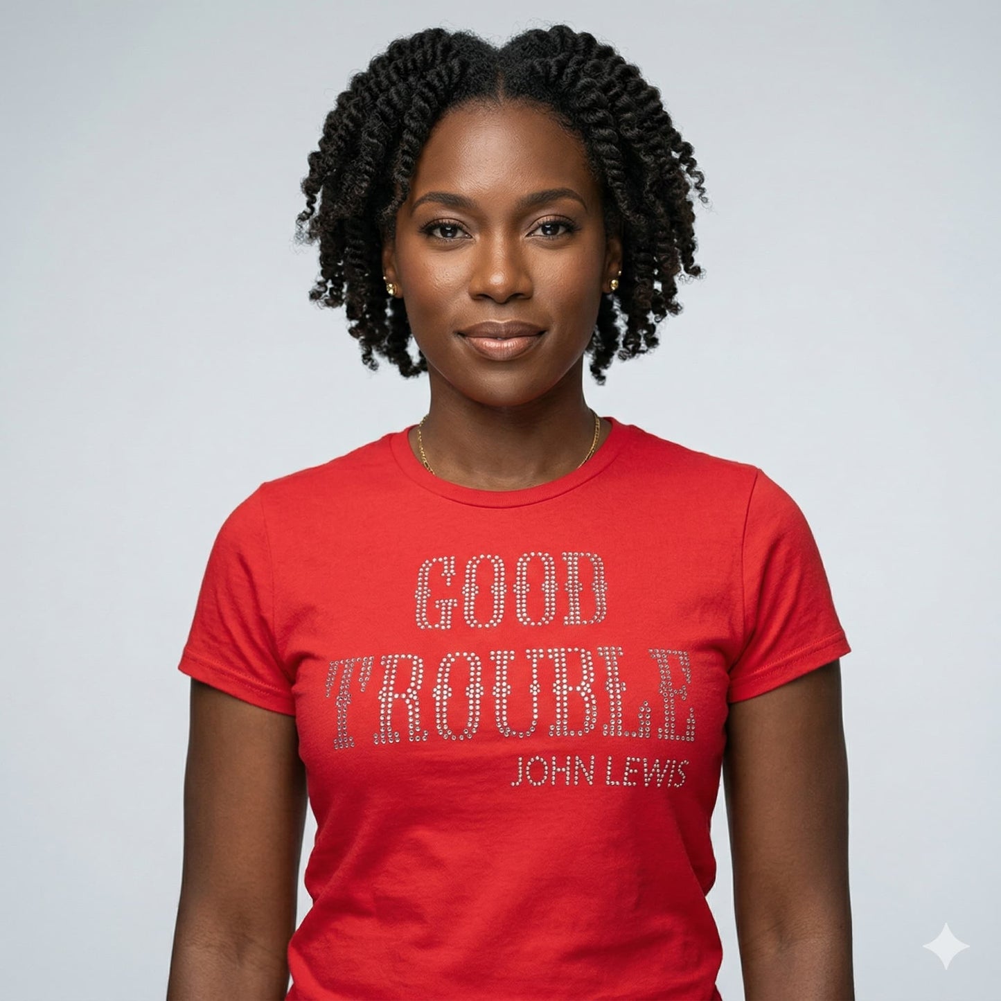 Woman wearing a fitted red combed cotton t-shirt with "GOOD TROUBLE JOHN LEWIS" in sparkling rhinestone lettering.