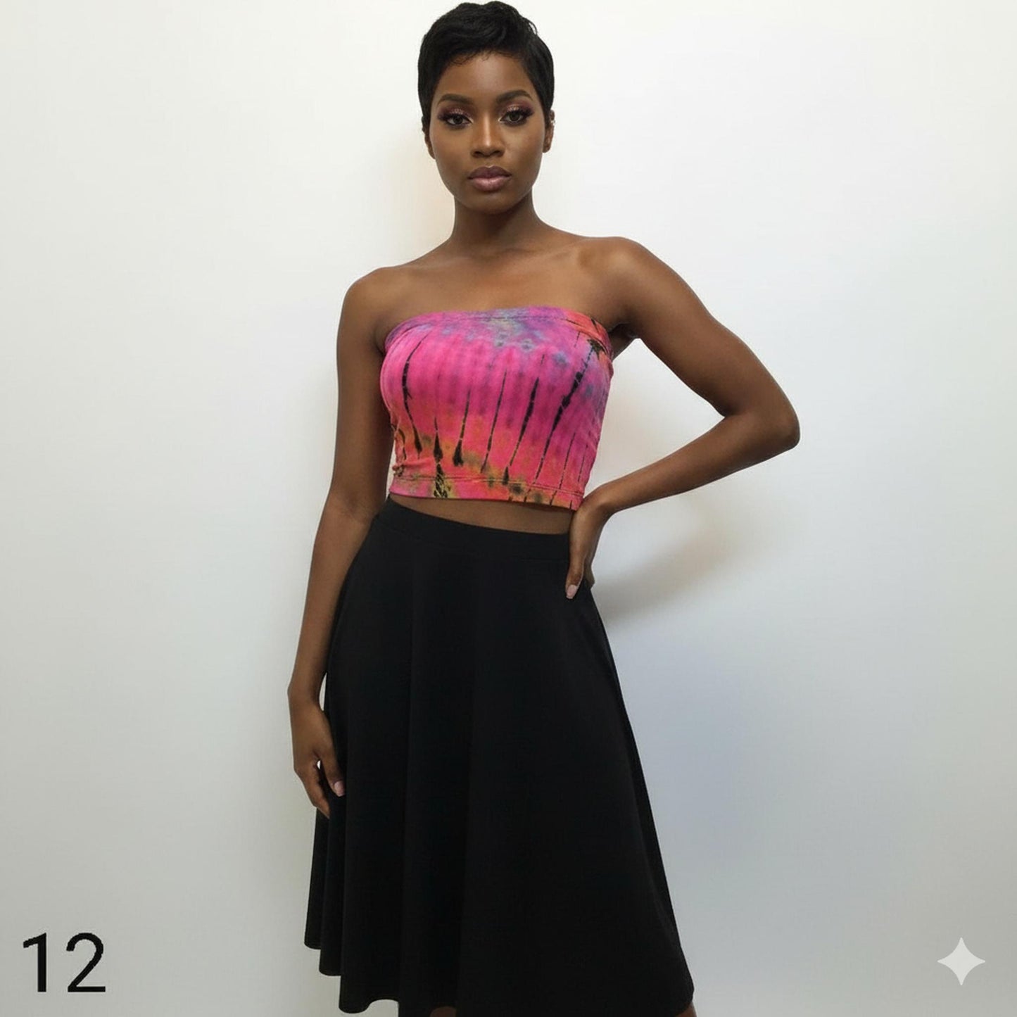 Woman wearing a pink tie-dye tube top and black skirt on a white background
