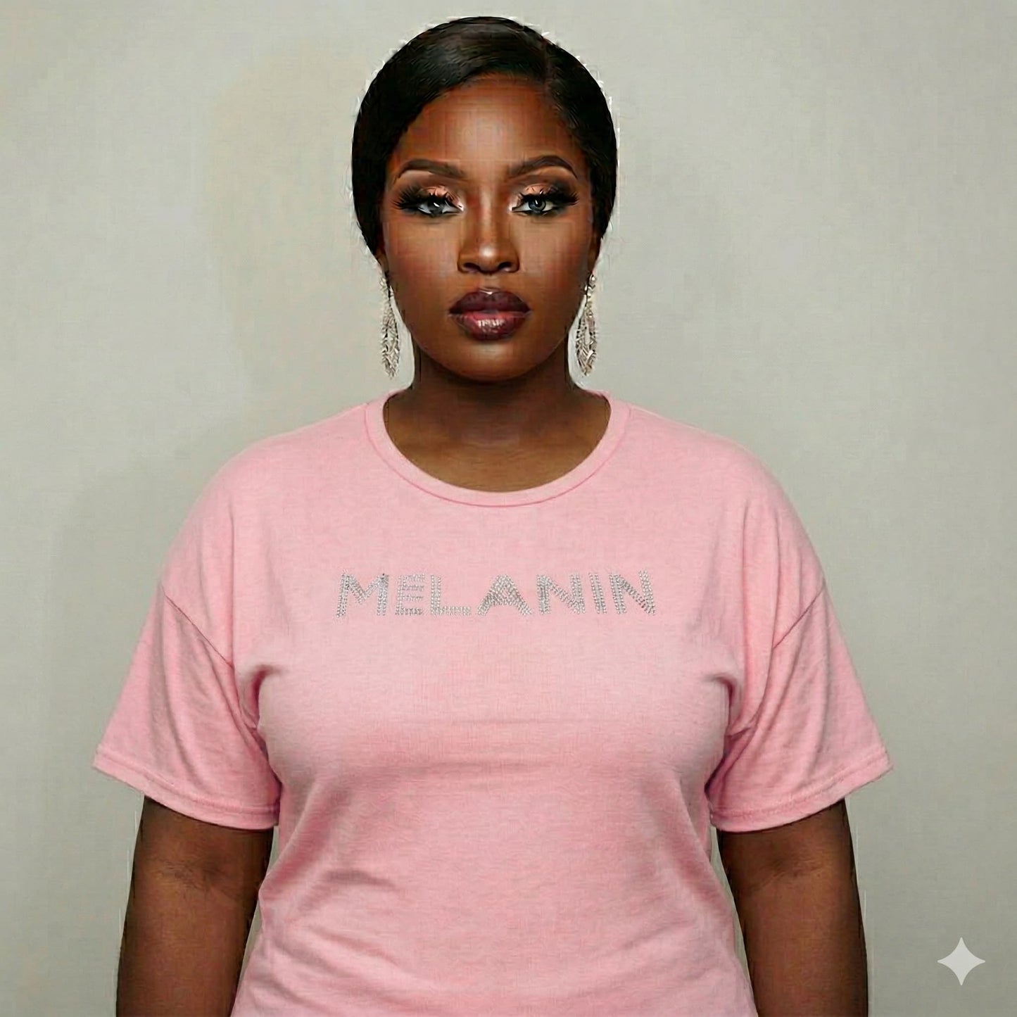 Woman in a pink Melanin Unisex T-Shirt with rhinestone "MELANIN" text, celebrating Black pride.