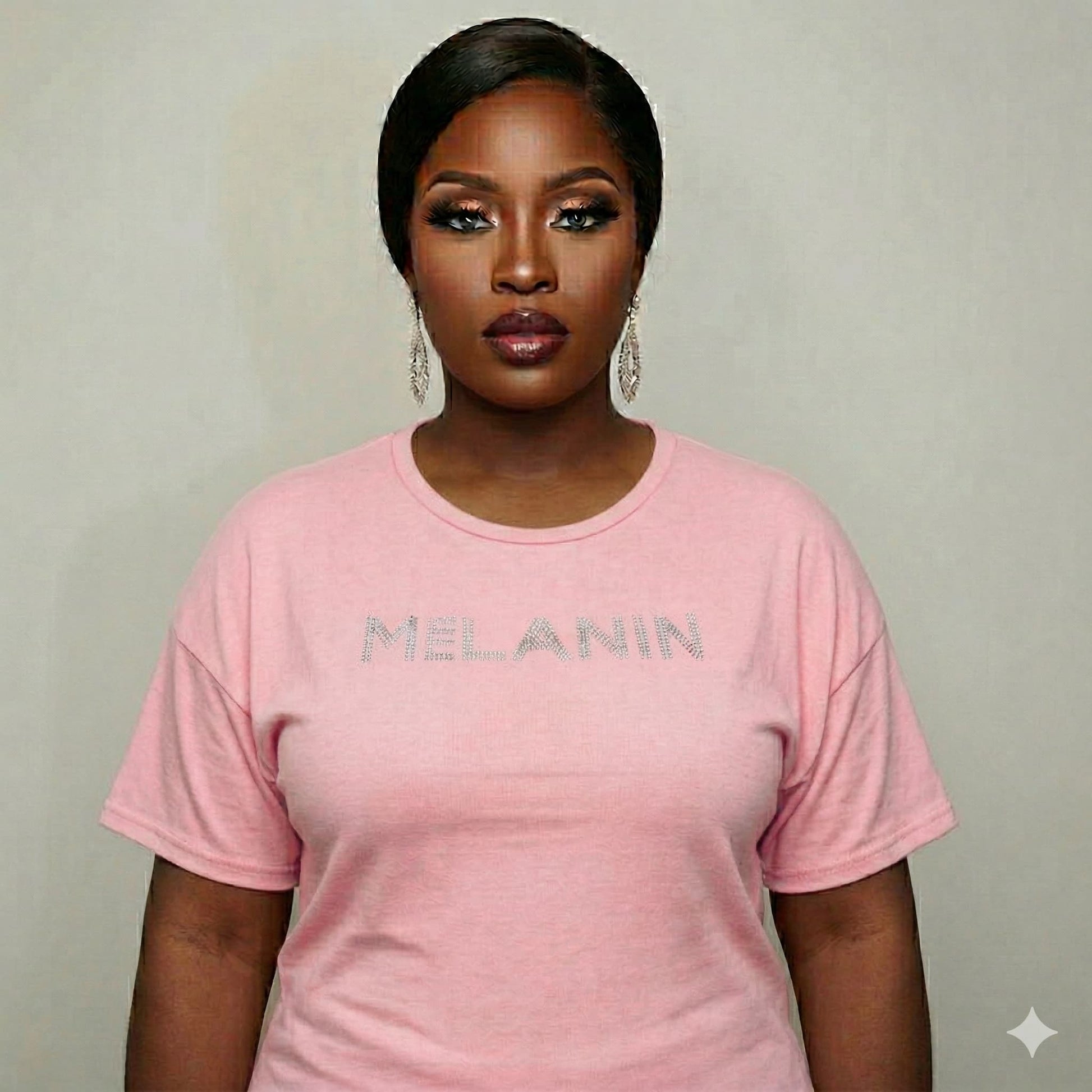 Woman in a pink Melanin Unisex T-Shirt with rhinestone "MELANIN" text, celebrating Black pride.