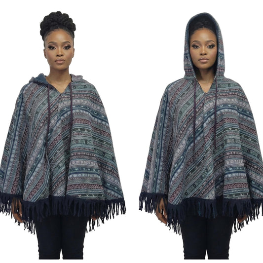 Woman wearing a patterned hooded poncho with fringes on a white background