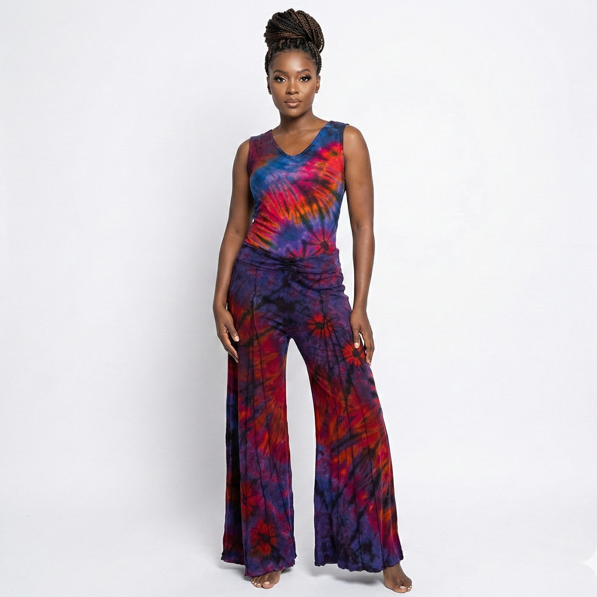 Woman wearing a tie-dye top and pants on a white background