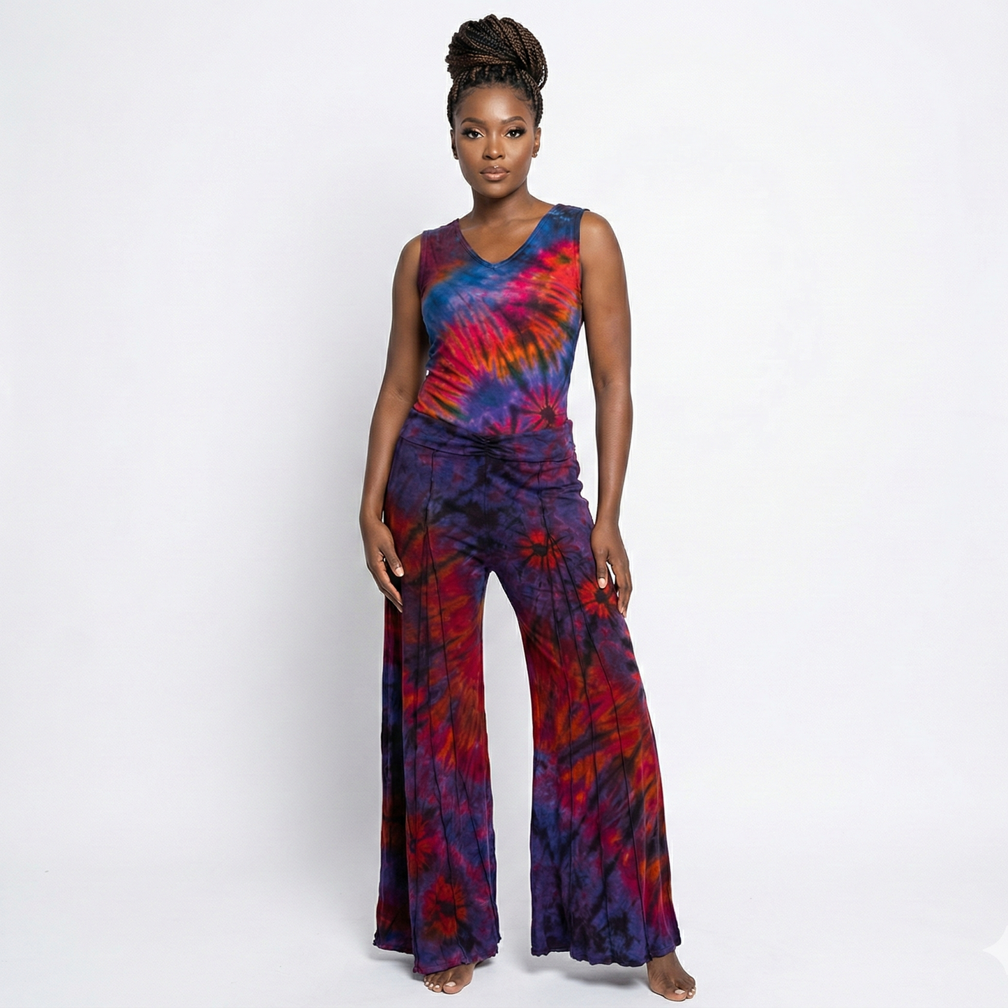Woman wearing a tie-dye top and pants on a white background