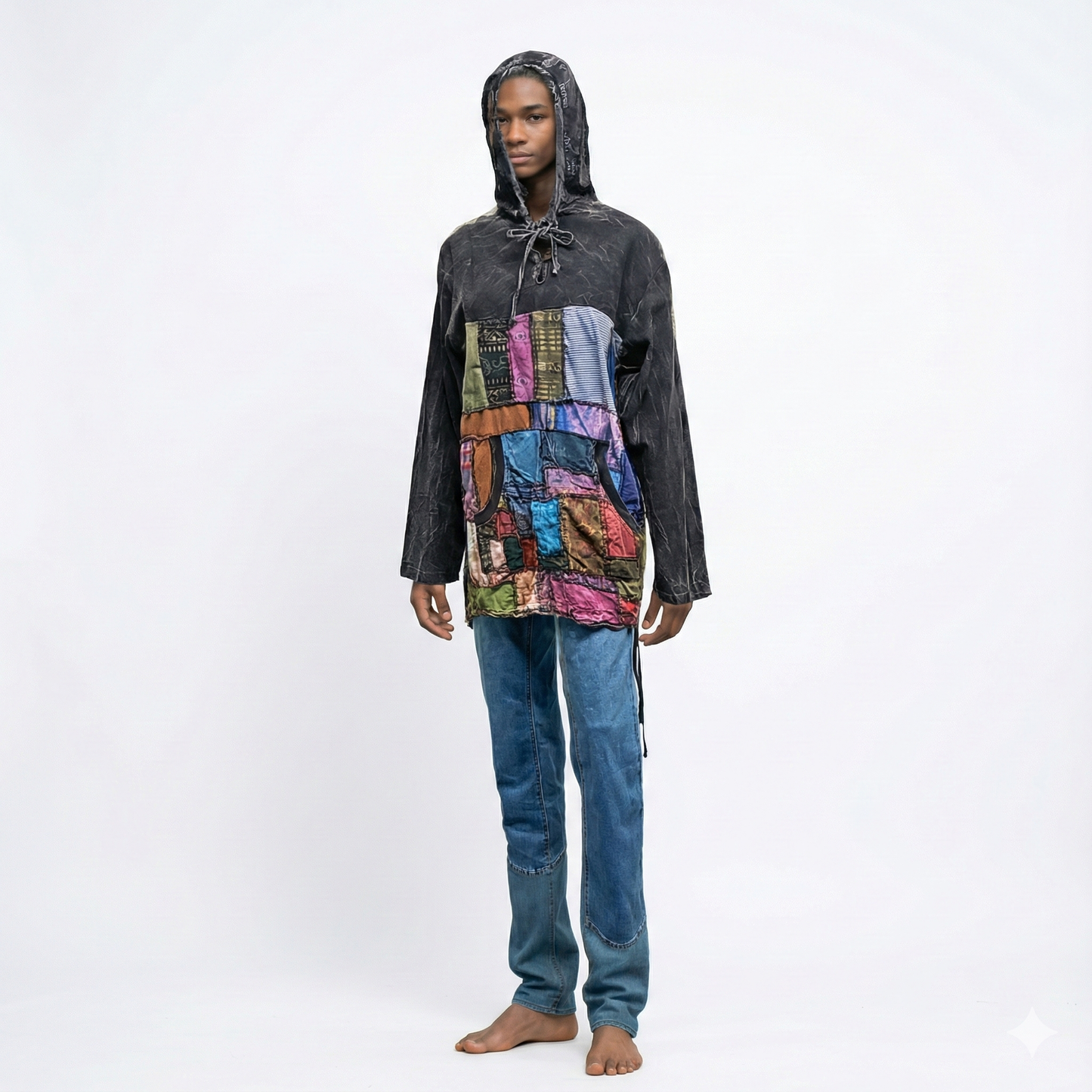 Person wearing a black hooded jacket with a colorful patchwork design on a white background