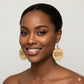 Woman wearing woooden earrings with 'Natural Beauty' text on a plain background