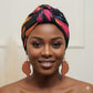 Woman wearing a colorful headscarf with a brown afro