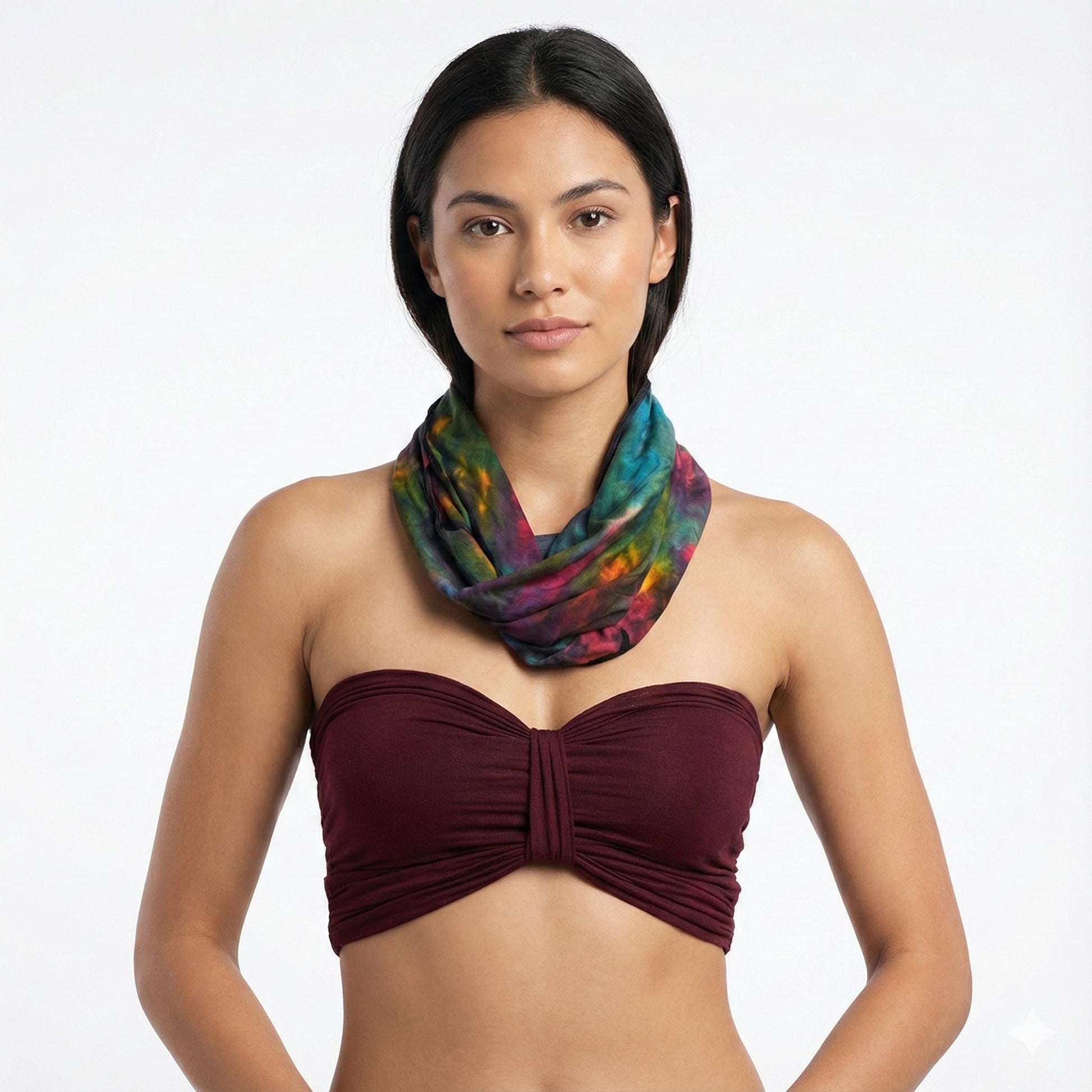 Woman wearing a colorful tie dye scarf and strapless top on a white background