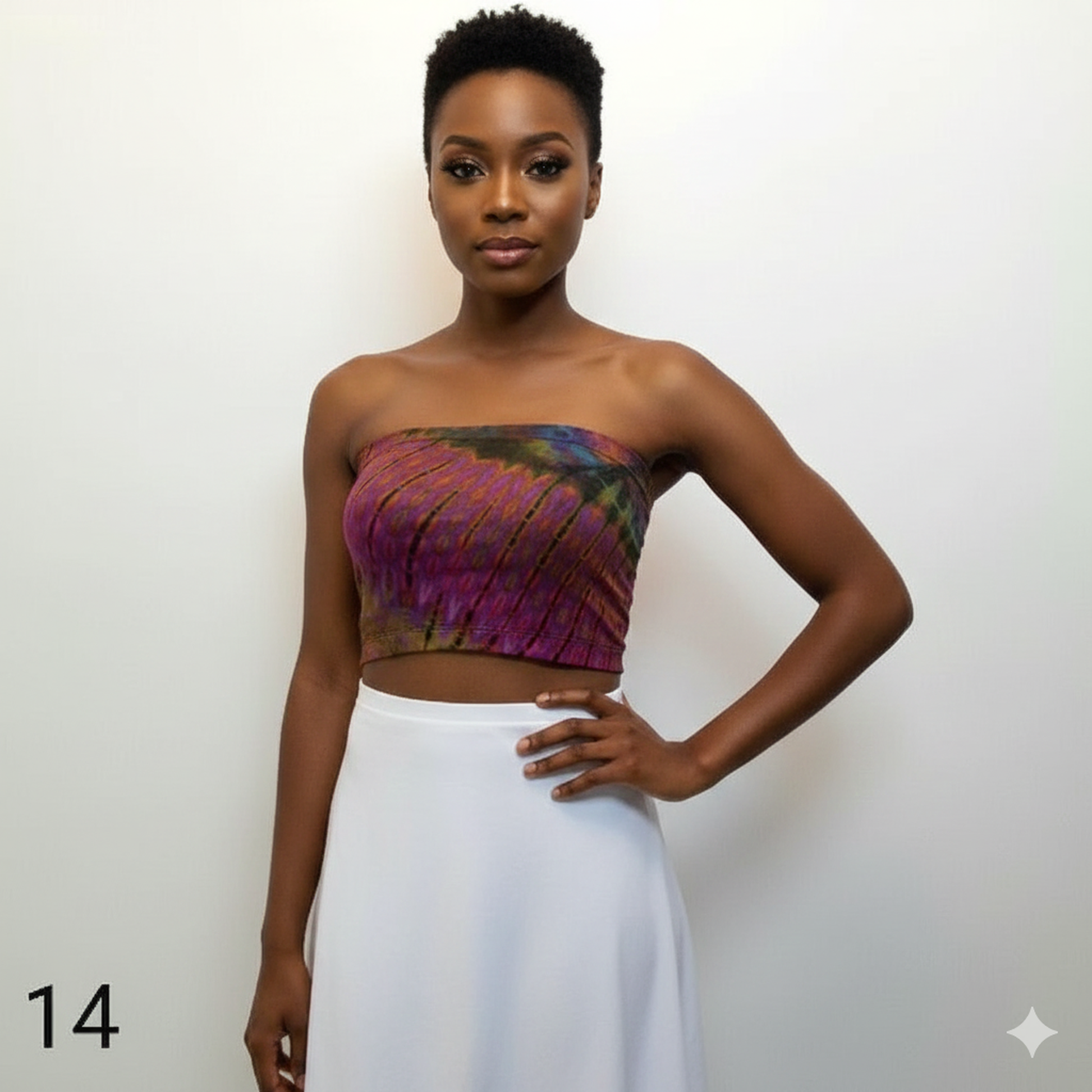 Woman wearing a colorful tube top and white skirt against a plain background