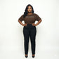 Woman in a brown "MELANIN" t-shirt and black pants, celebrating Black pride and beauty.
