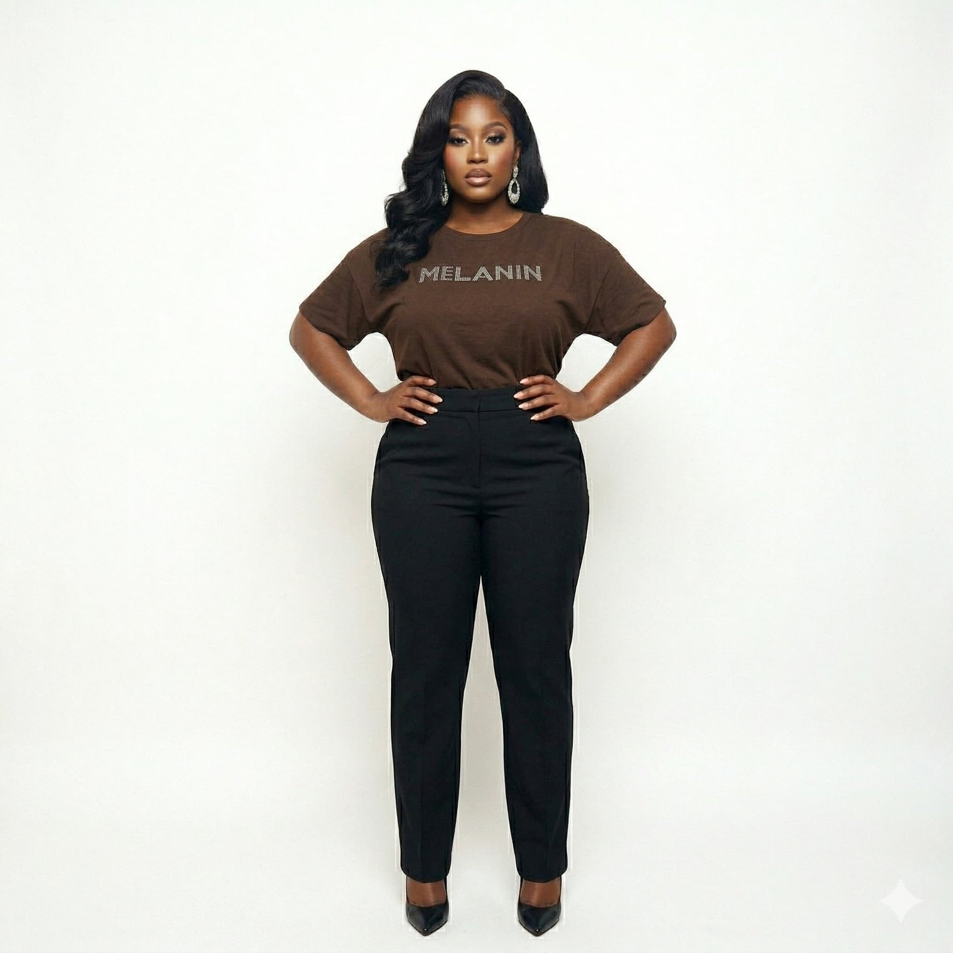 Woman in a brown "MELANIN" t-shirt and black pants, celebrating Black pride and beauty.