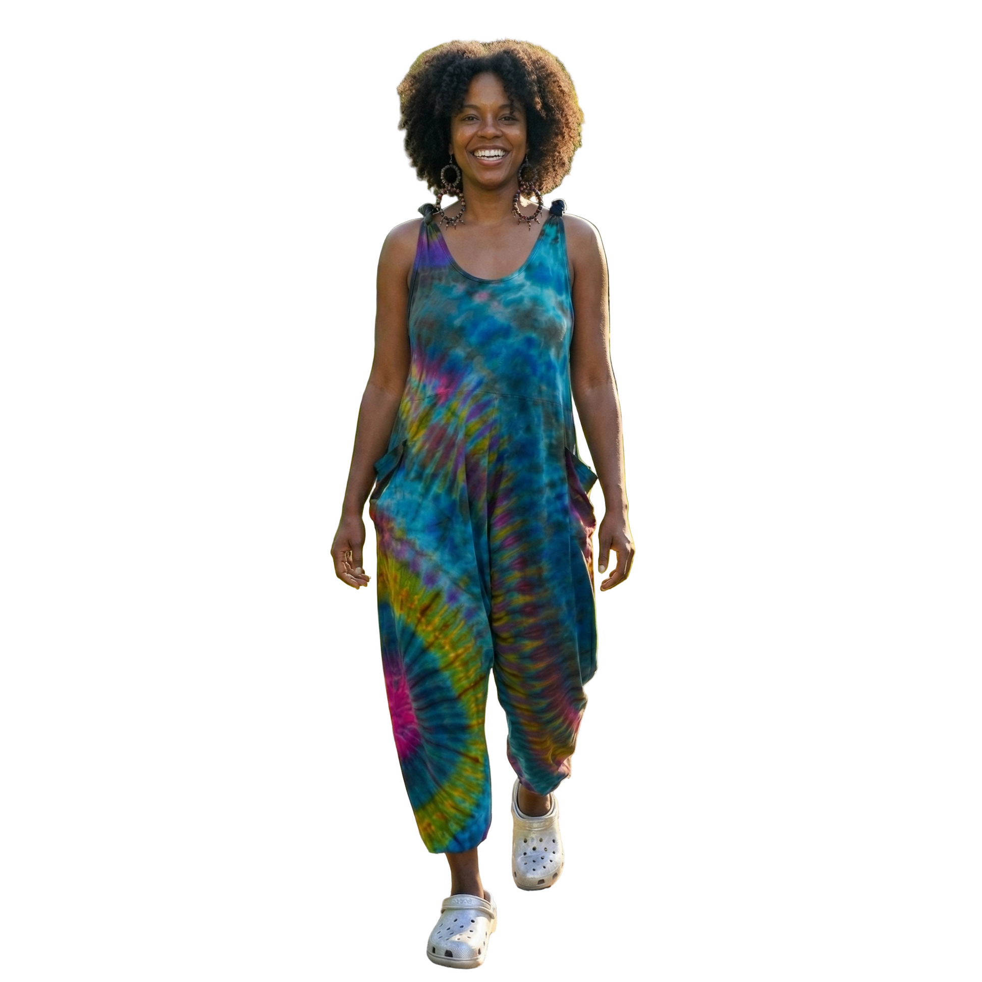 Woman in a tie-dye jumpsuit walking on a path in a park
