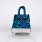 Blue patterned batik handbag with a chain detail on a white background