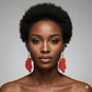 Woman wearing red wooden earrings against a gray background