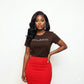 Woman in a brown "MELANIN" bling tee, red skirt, and statement earrings.
