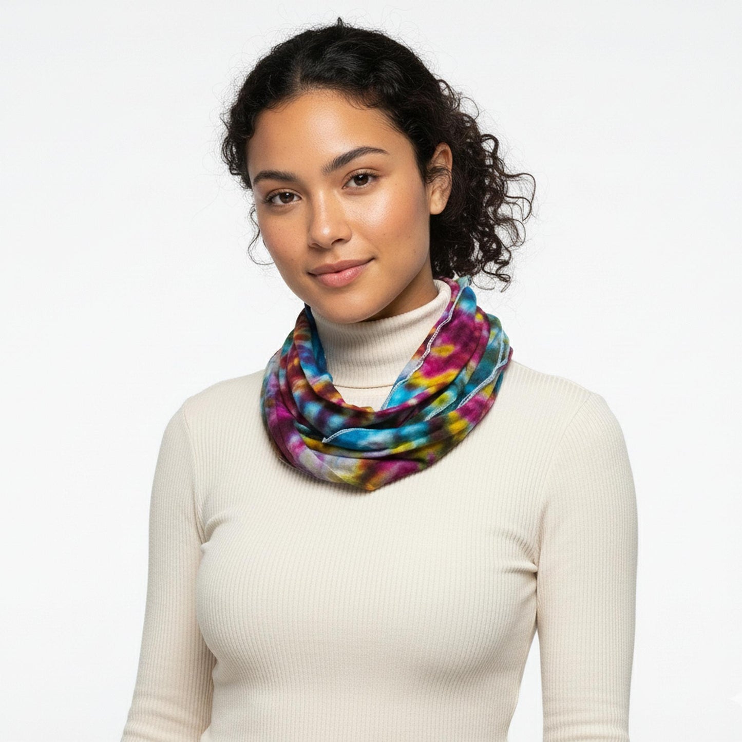 Woman wearing a colorful tie dye scarf on a white background