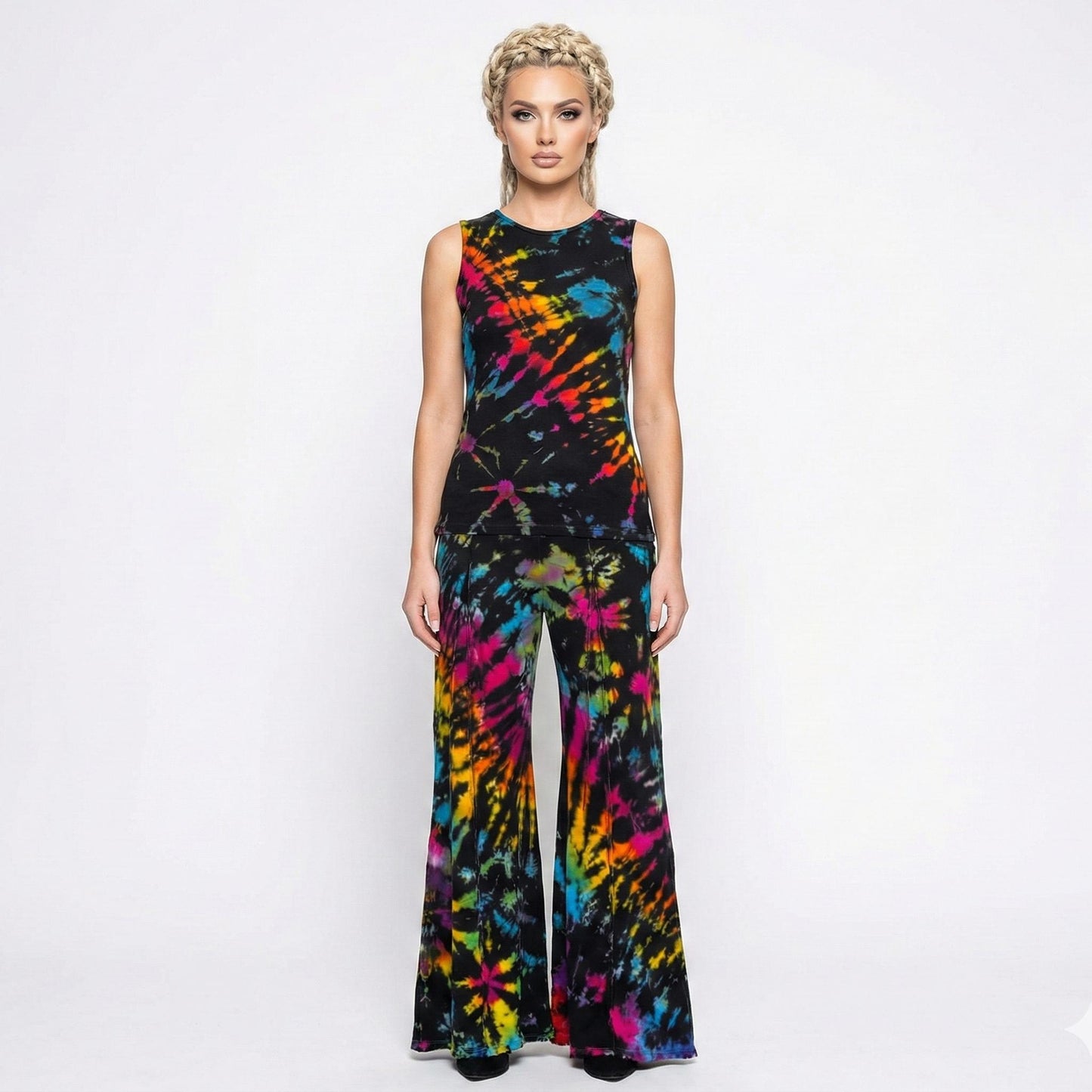 Woman wearing a colorful tie-dye  pants and top on a white background