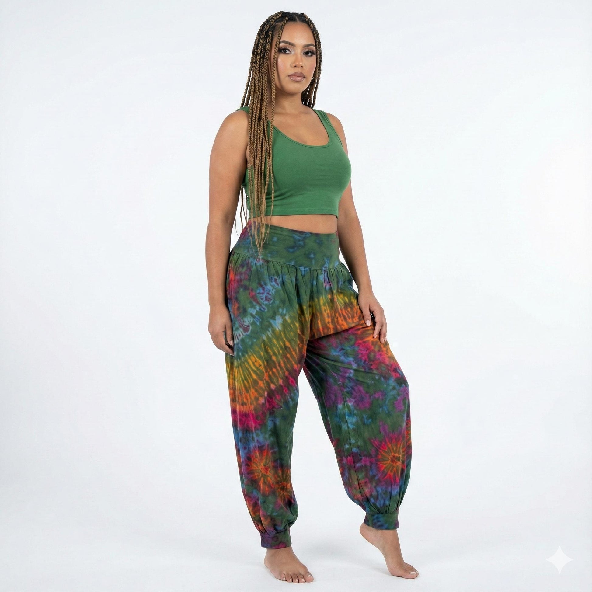 Woman wearing a green top and colorful tie-dye pants on a white background