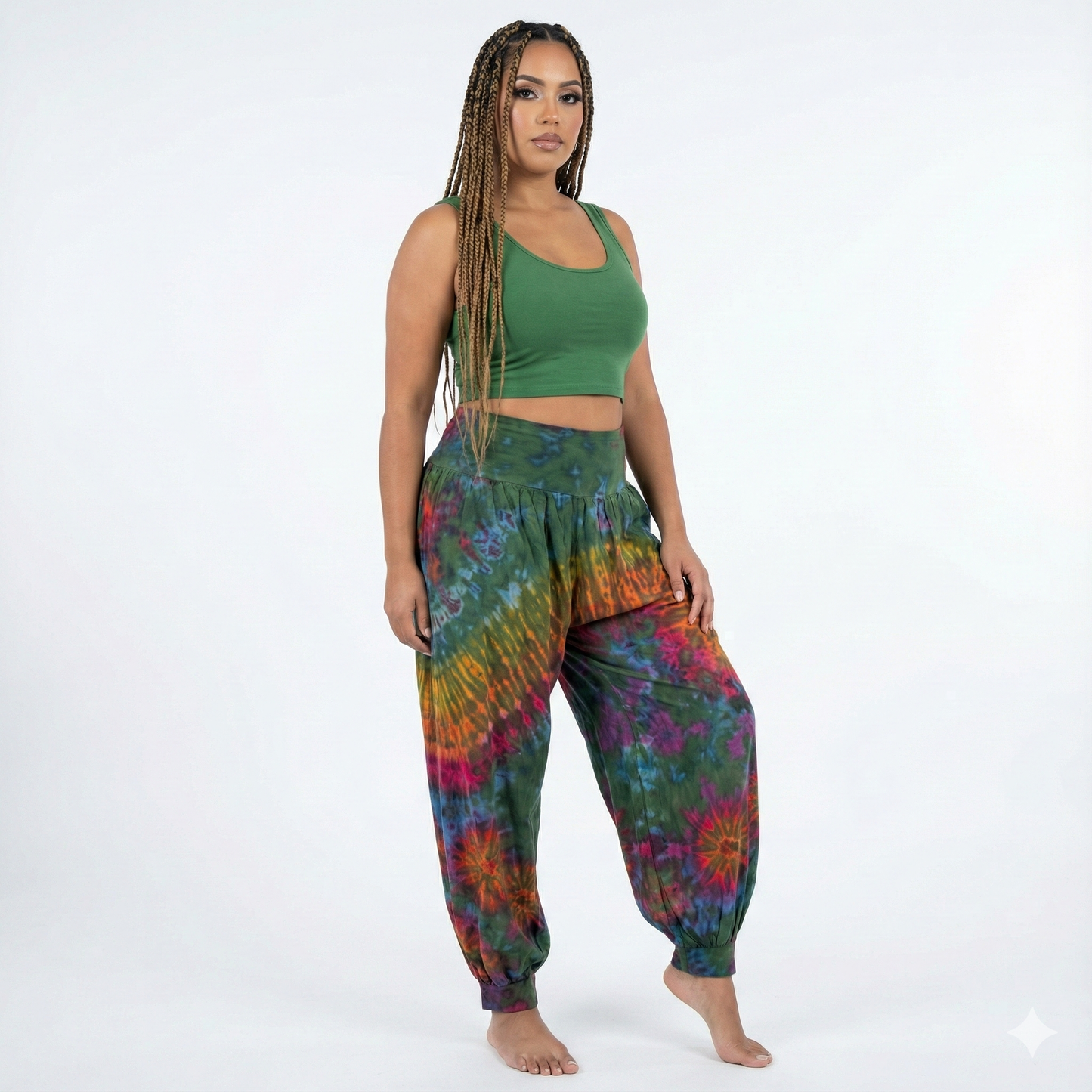 Woman wearing a green top and colorful tie-dye pants on a white background