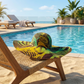 Colorful Batik  hat on a lounge chair by a pool with a scenic background