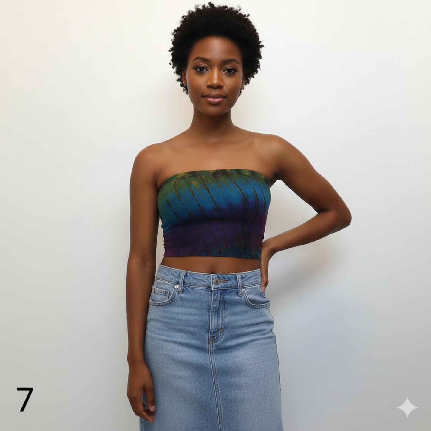 Woman wearing a tube top with a tie-dye pattern and a denim skirt on a white background