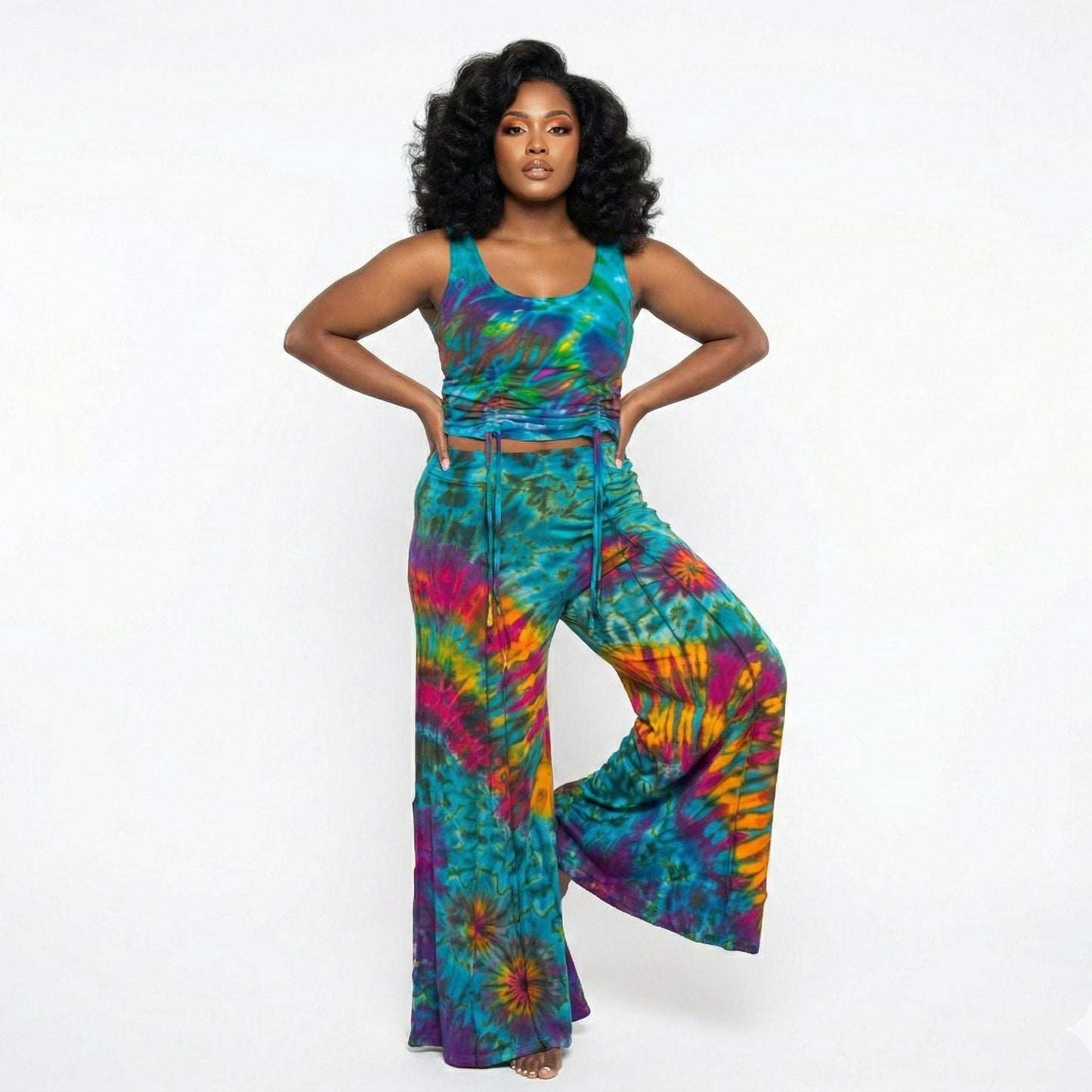 Woman wearing a colorful tie-dye top and pants on a white background