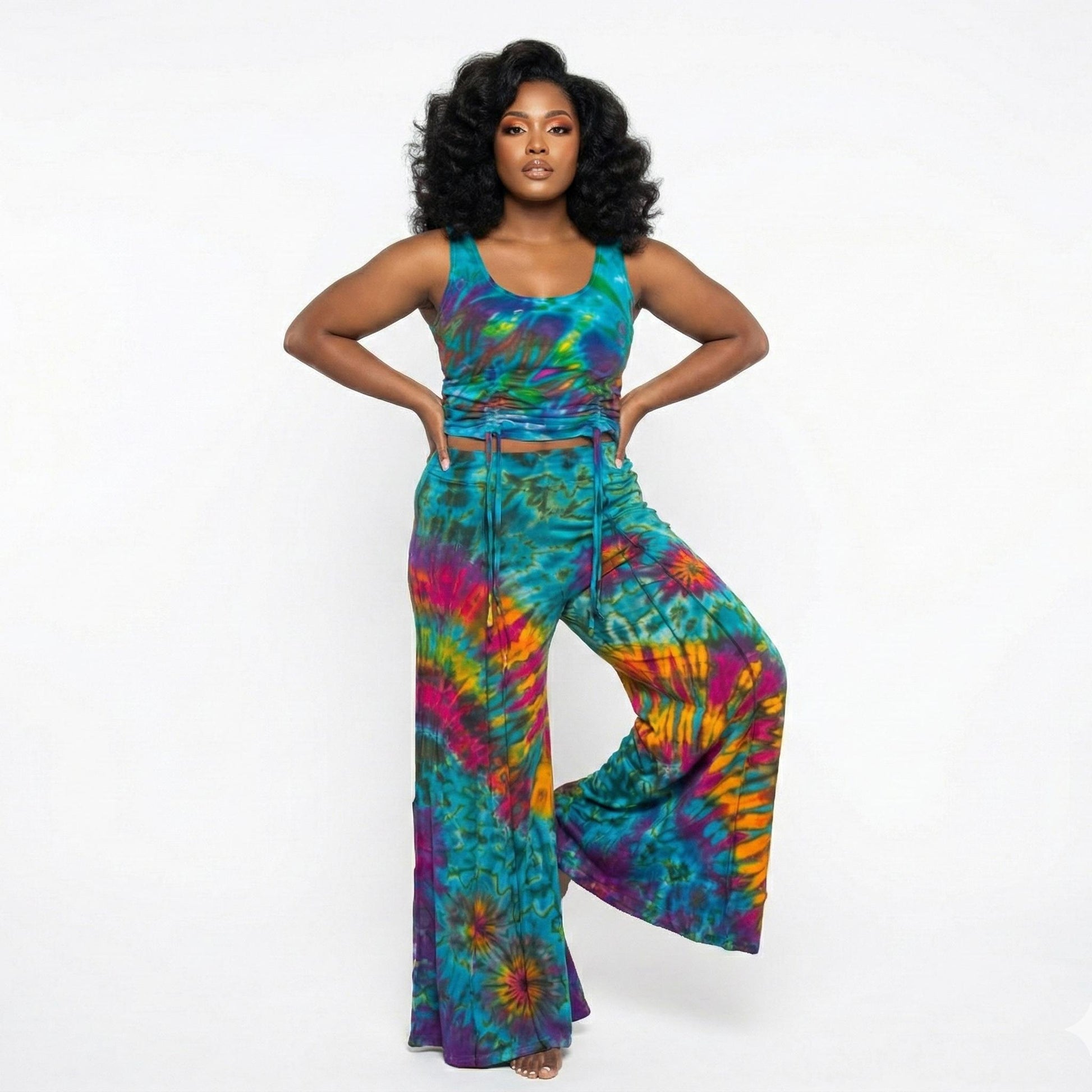 Woman wearing a colorful tie-dye top and pants on a white background