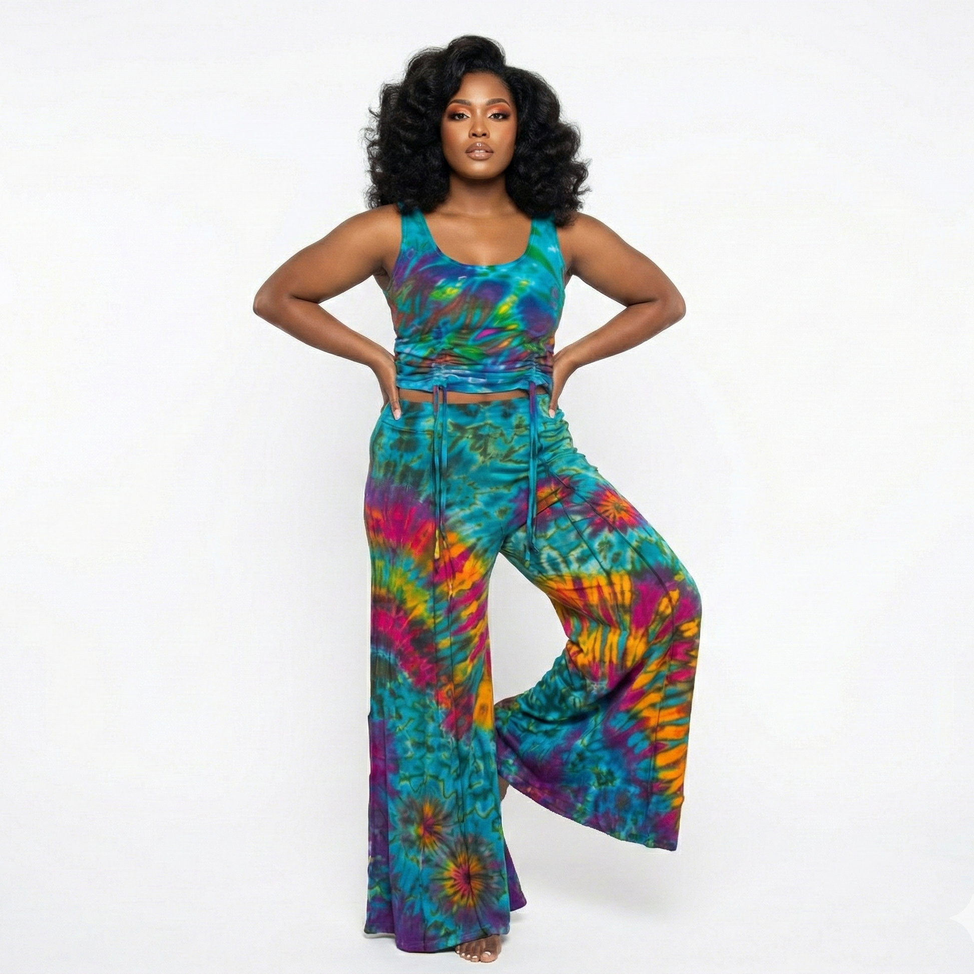 Woman wearing a colorful tie-dye top and pants on a white background