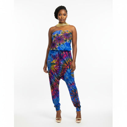Woman wearing a colorful tie-dye strapless jumpsuit on a white background