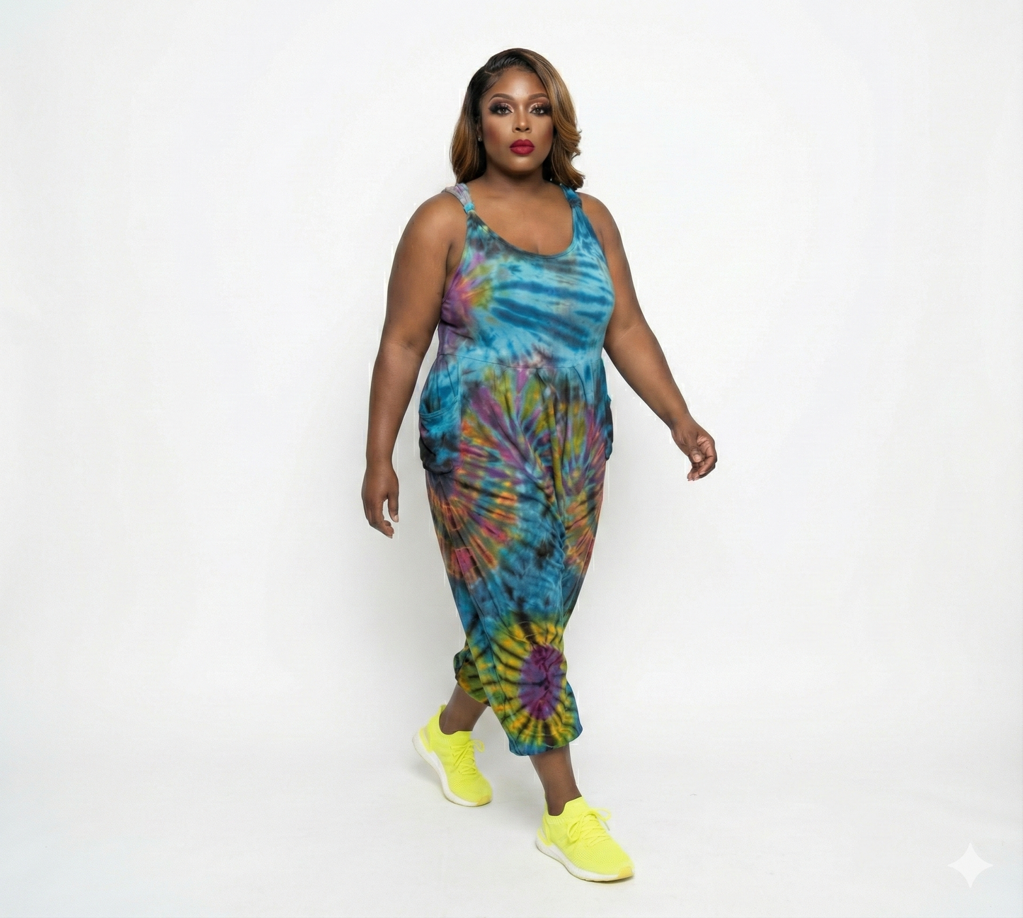 Woman wearing a tie-dye jumper with colorful patterns on a white background