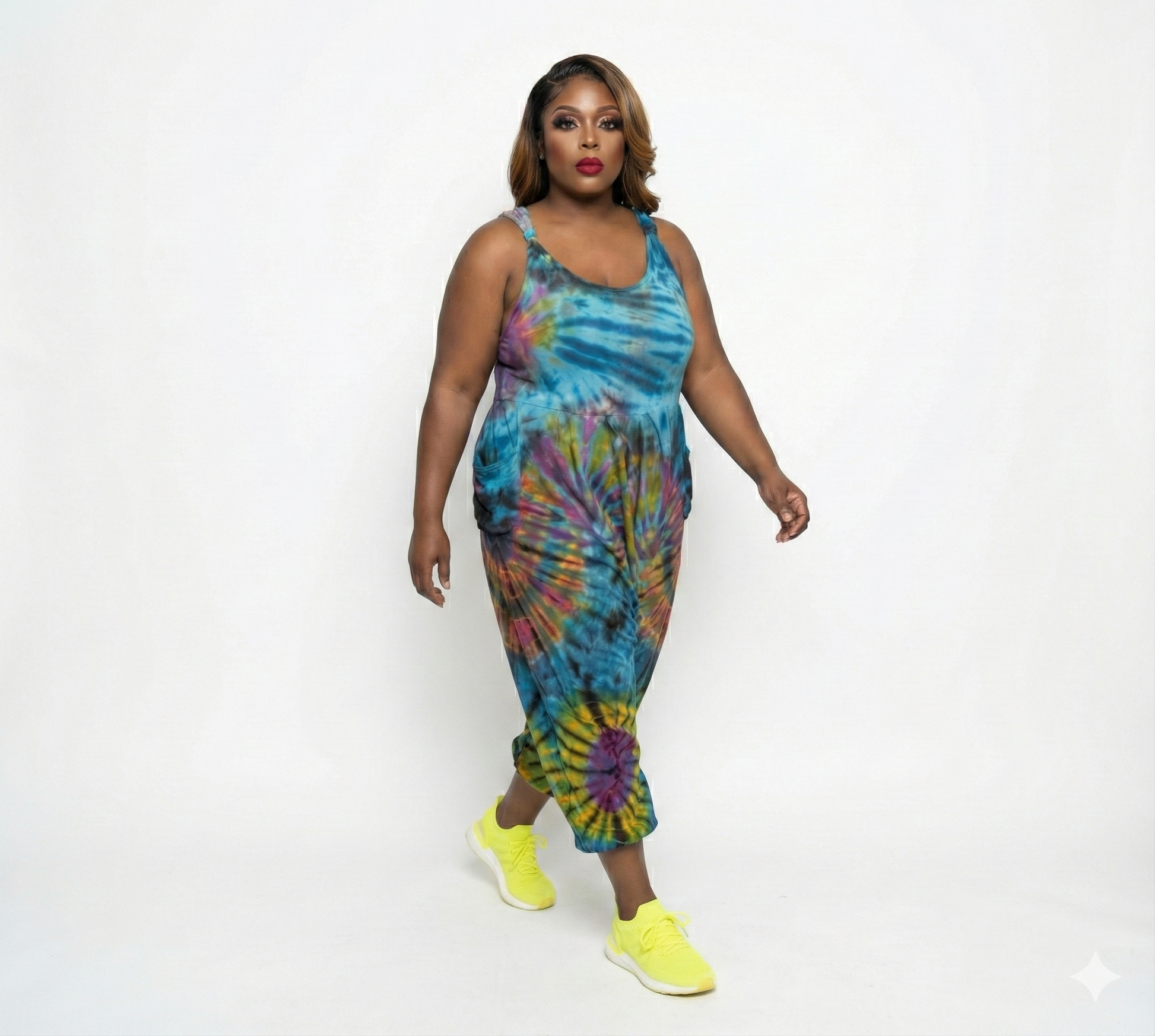 Woman wearing a tie-dye jumper with colorful patterns on a white background