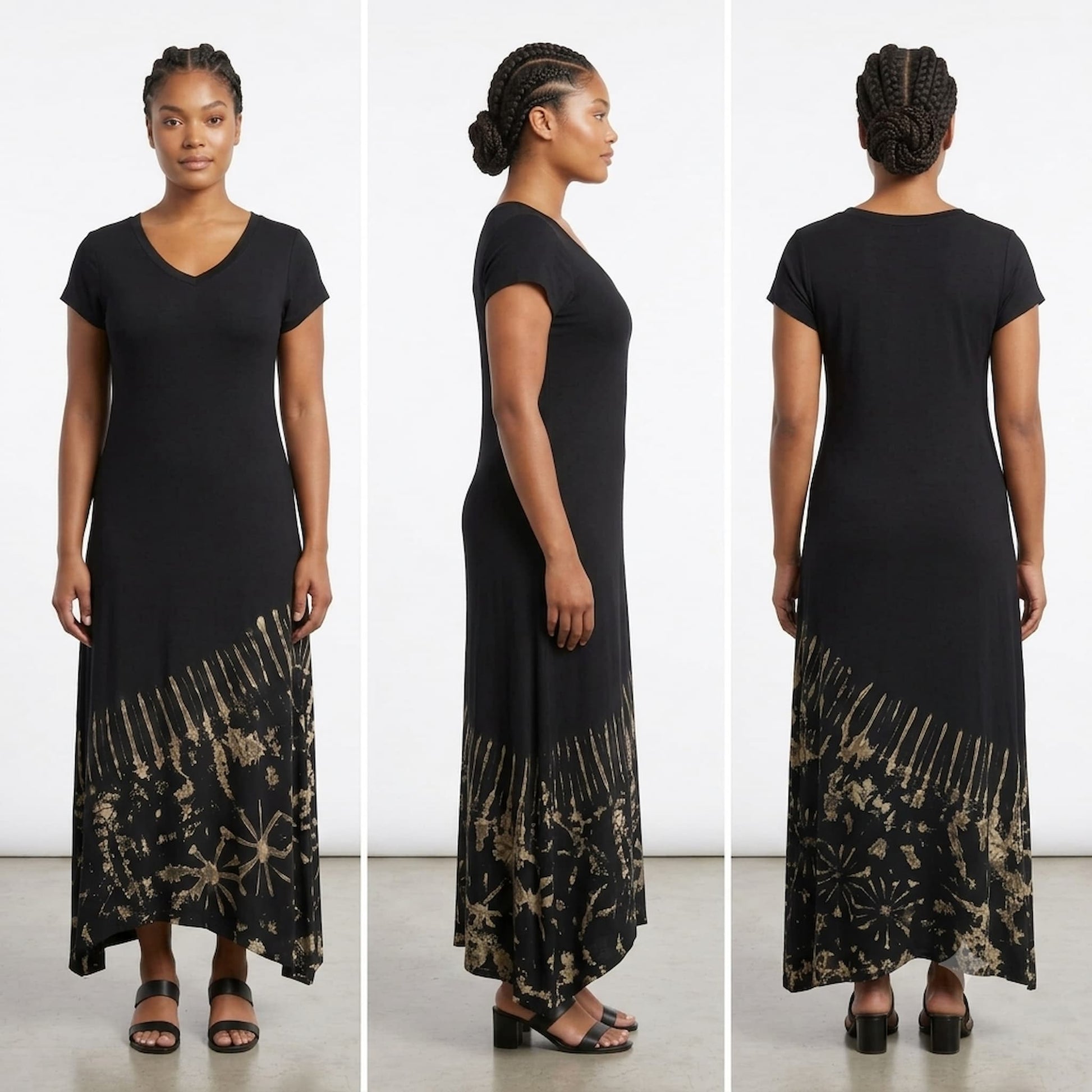 A woman modeling a black maxi dress with a beige floral and geometric print concentrated at the hem.