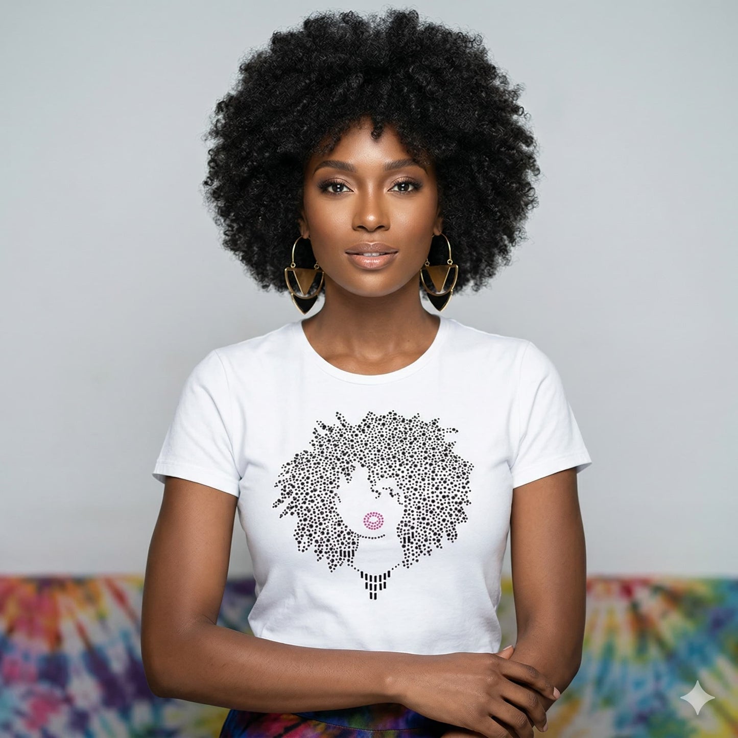Woman in white t-shirt with rhinestone Afro design and pink lips, gold earrings.