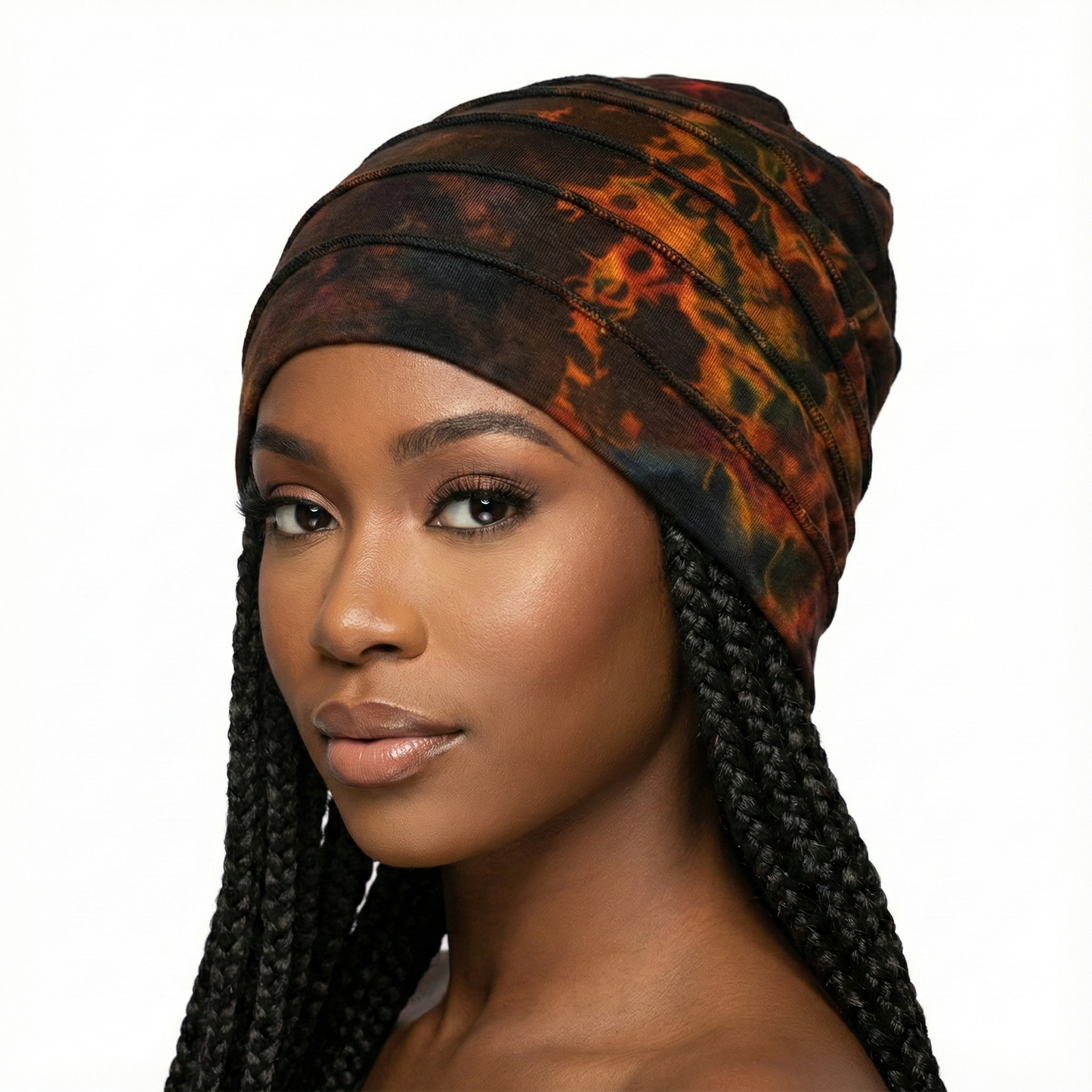 Woman wearing a tie dye hat with braided hair on a white background