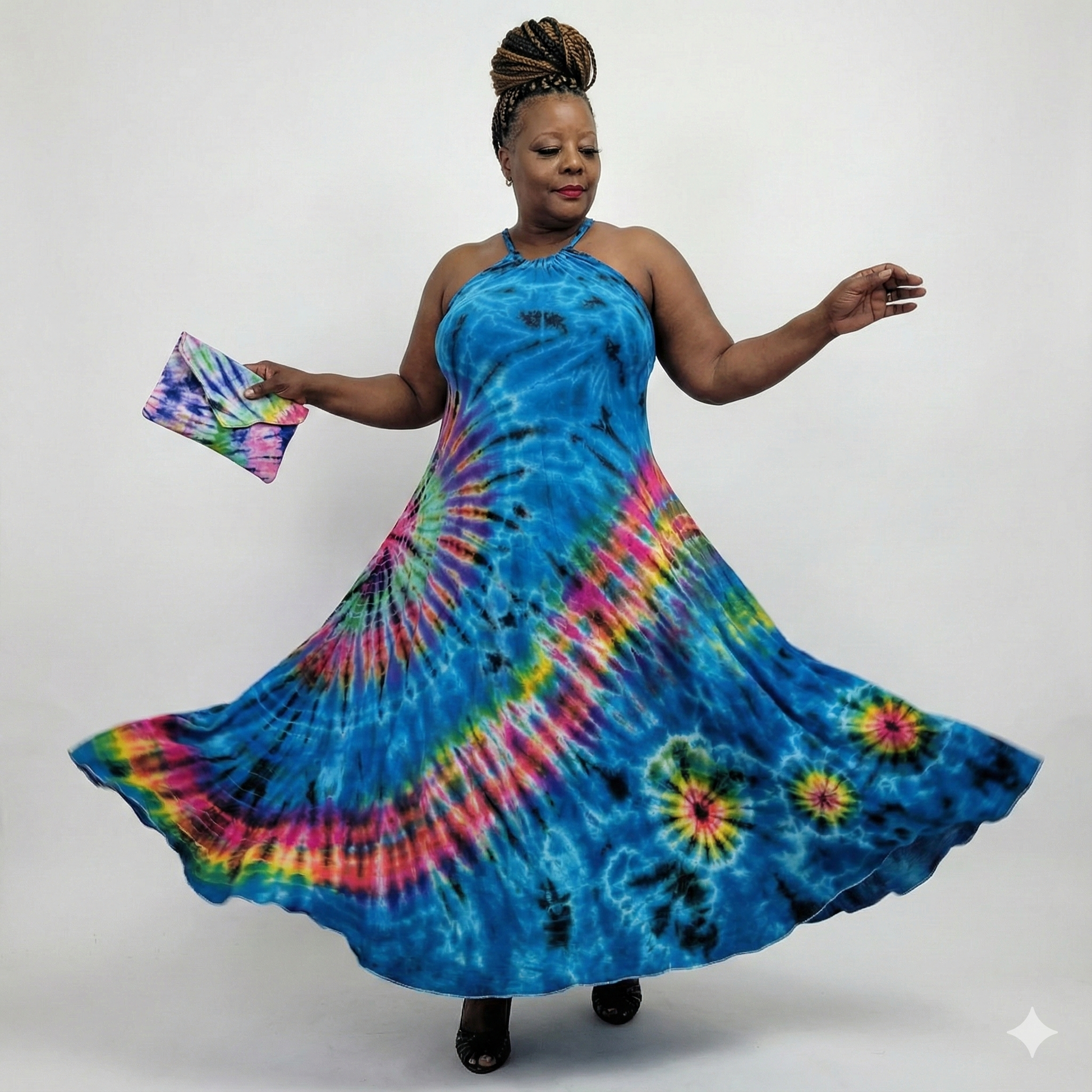 Woman wearing a tie-dye dress with a colorful clutch against a white background
