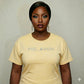 Woman in a yellow "MELANIN" bling tee, showcasing Black pride and beauty.